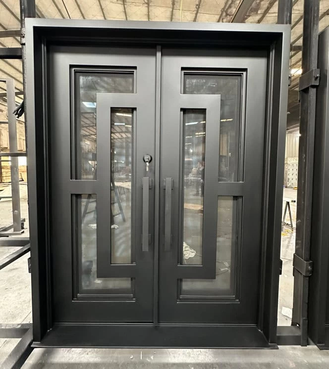 Modern black double doors with geometric rectangular glass panels and long vertical handles, set in an industrial space with metal structures and a high ceiling visible in the background.